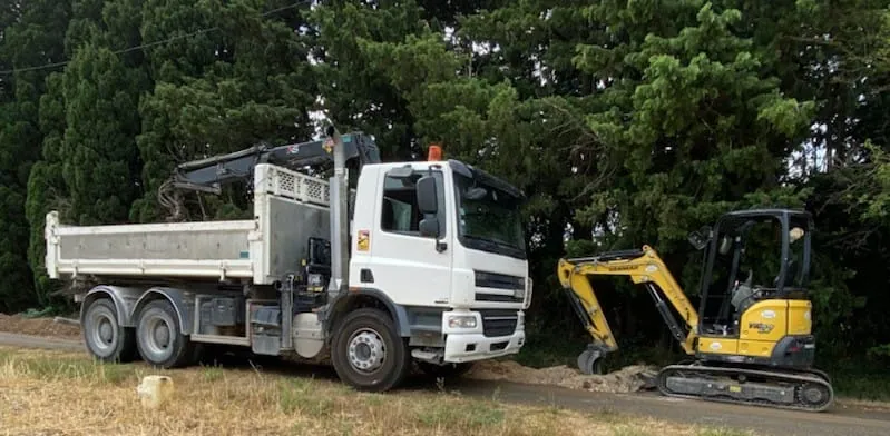 Camion benne et mini-pelle sur un chantier de réseaux